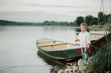 Fototapeta na wymiar Child on a small boat on the bank of the Vistula River.