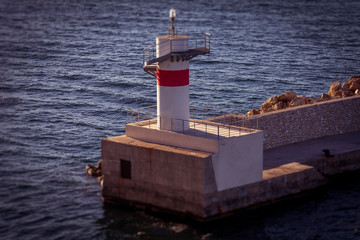 Tilt shift effect of pier and lighthouse at the entrance to the port of Piraeus