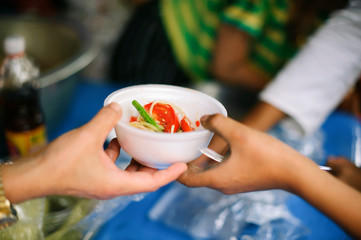 Poor people receive donated food from donors: The hands of the poor receive food from the hands of the humane : the concept of relief