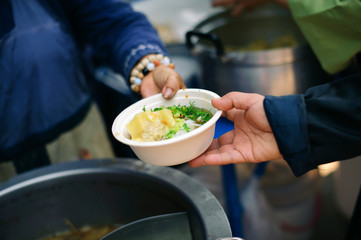 the concept of social inequality : Donating food to beggars to alleviate hunger : The hands of the poor receive food from the hands of the humane