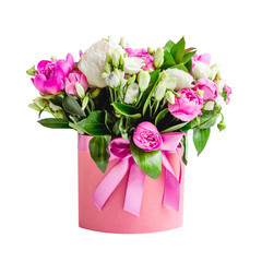 Arrangement of flowers in a hat box. Bouquet of pink and white peonies, eustoma, spray rose in a pink box with an oasis isolated on a white background with copy space