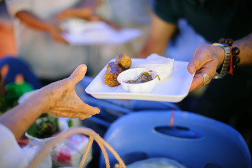 the concept of social inequality : Donating food to beggars to alleviate hunger : The hands of the poor receive food from the hands of the humane