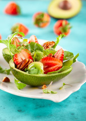 Stuffed avocado  with strawberries  and nut .