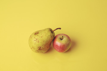 Seasonal pear and apple on yellow background