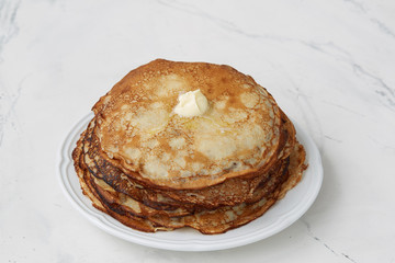 Freshly Cooked Buttered Pancakes on a light background