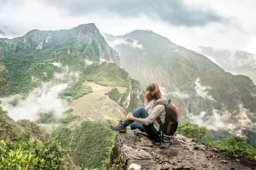 Papier Peint photo Machu Picchu Girl-hiker looking on top of Huayna Picchu, looking on Machu Picchu