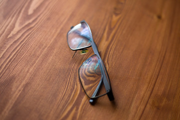 Fototapeta premium glasses with transparent lenses to improve vision on a wooden background close-up 