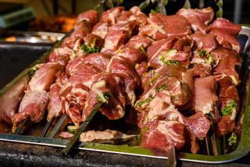 Skewers with raw meat over the charcoals. Cooking shashlik