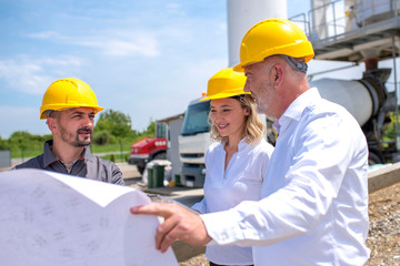 Group of engineers on site, visiting ready mix concrete plant and discussing construction plan