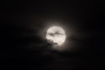 full moon under heavy clouds