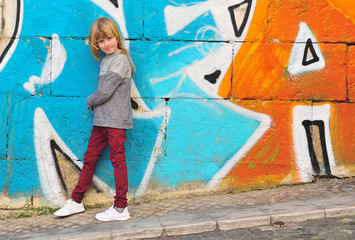 Smiling boy standing at colorful wall