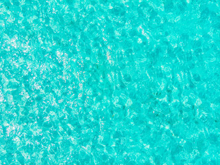 Background blue turquoise sea, transparent water with texture of waves, sunny day. Aerial view