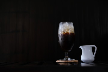 Iced coffee with fresh milk on wooden table