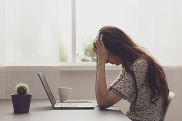 Tired stressed woman sitting at desk and connecting