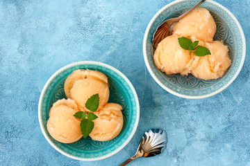 Homemade melon, apricot or peach ice cream , sorbet in bowl with  mint leaves. Top view, copy space - obrazy, fototapety, plakaty