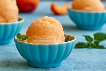 Homemade apricot or peach ice cream , sorbet in bowl with  mint leaves. Closeup