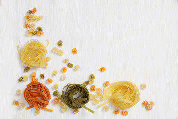 Pasta products nests of different colors on a white background. Copy of space.Concept still life.