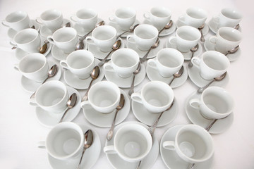 White dishes: cups and saucers for tea or coffee on a white background. View from above. Isolated object. A lot of dishes on a white background. A concept of still life.