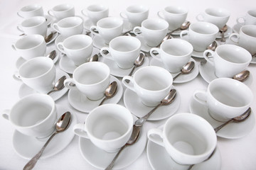 White dishes: cups and saucers for tea or coffee on a white background. View from above. Isolated object. A lot of dishes on a white background. A concept of still life.