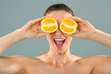beautiful young woman on a background with orange slices in hands
