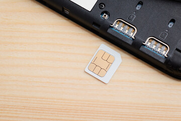 Micro SIM card near SIM port of a mobile phone on table