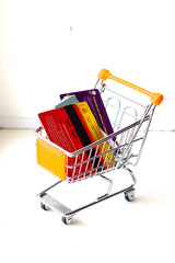 Shopping cart with credit cards and money on white isolated background