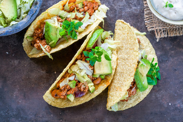 Smoky Mexican pork and bean tacos with lettuce and avocado salad