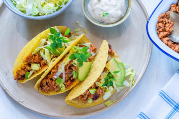 Smoky Mexican pork and bean tacos with lettuce and avocado salad
