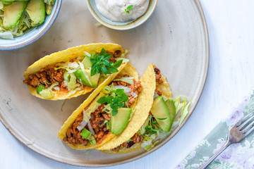 Smoky Mexican pork and bean tacos with lettuce and avocado salad