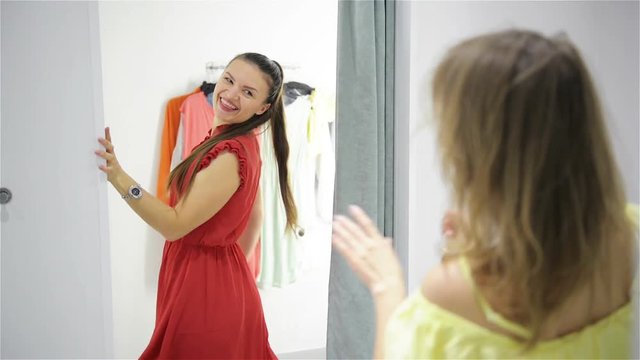 Best Friends Helping To Each Other In The Fitting Room. Yound Fashion Woman Changing Her Outfits.