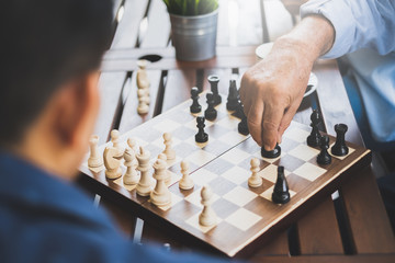 Senior old man playing chess game on chess board for strategy and planning concept