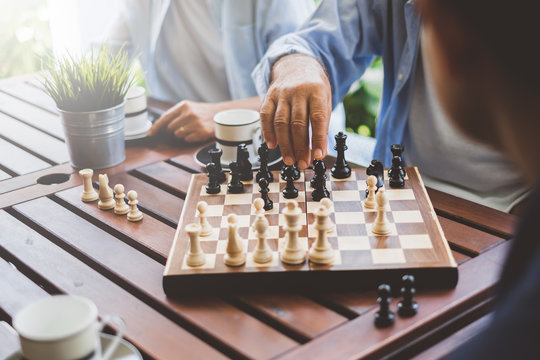 Senior old man playing chess game on chess board for strategy and planning concept