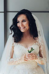 Bride in white luxury dress is getting ready for wedding. Morning preparations. Woman putting on dress.