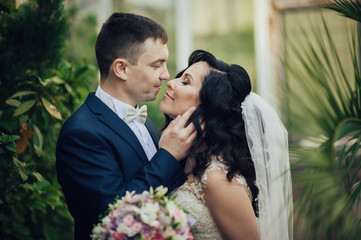 Beautiful bride and groom embracing and kissing on their wedding day.