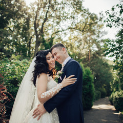 Beautiful bride and groom embracing and kissing on their wedding day.