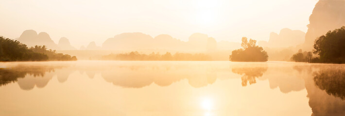 Naklejka na ściany i meble Panoramic scenery of tropical lake in the morning mist.