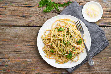 Pesto spaghetti pasta with basil, garlic, pine nuts, olive oil. Copy space. Rustic table