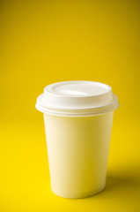 Take away coffee on yellow background