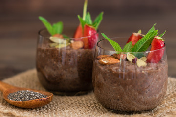 Beautiful and tasty dessert with cocoa, strawberry and seeds of a chia. A fresh pudding with fruit for breakfast