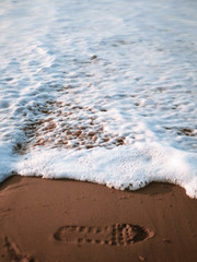 Footstep being washed on the shoreline