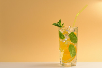 Cocktail with lemon and mint on a beige background. Copy space.