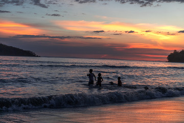 Fototapeta premium Kinder spielen am Strand beim Sonnenuntergang in Panama