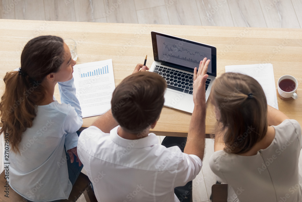 Wall mural top view businesswomen and businessman having conversation at laptop