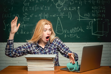Student with laptop. Education. Student sitting at table and writing on notebook. Student angry. Crying emotional angry woman student screaming on classroom chalkboard background.