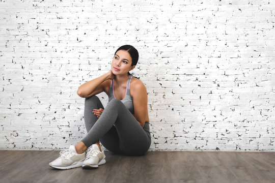 Sport woman in sportswear relax after workout against copy space for adding text with white wall background.Diet concept.Fitness and healthy lifestyle
