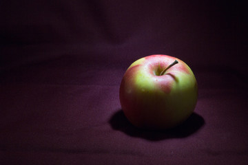 red apple on wooden table in the twilight