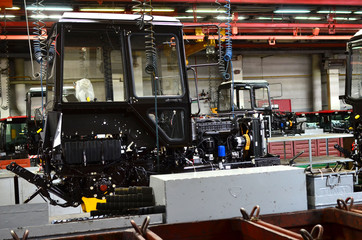 Tractor Manufacture work. Assembly line inside the agricultural machinery factory. Installation of...
