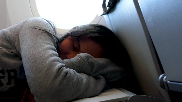 Young Asian American girl sleeping on airplane