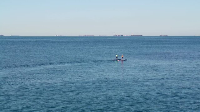 Sportsman rower on a kayak. Sunny day. People do sports. People ride on boats. People rowing oars standing on the boat. Sportsman rower on boat. Extreme sport. 