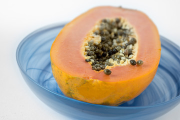 Halved papaya in a blue bowl